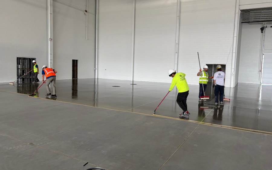 Maverick crew rolling MavPrime MVT moisture-tolerant epoxy primer across a new concrete slab
