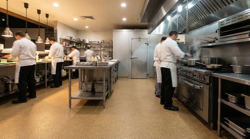 Commercial kitchen line with seamless urethane cement floor and integral cove base